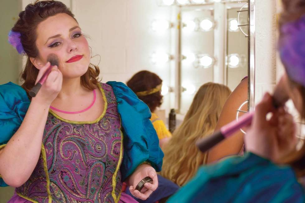 woman applying makeup backstage